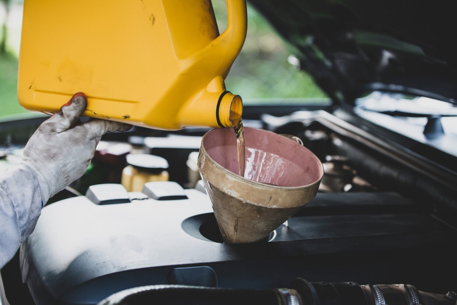 mechanic changing oil filter under car