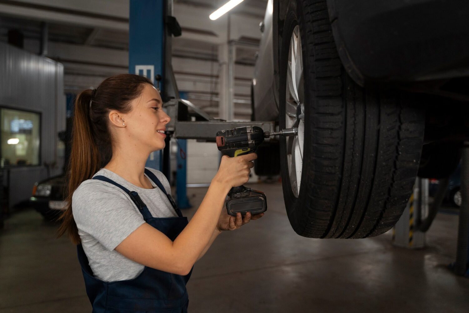 mechanic inspecting car wheel alignment in a garage